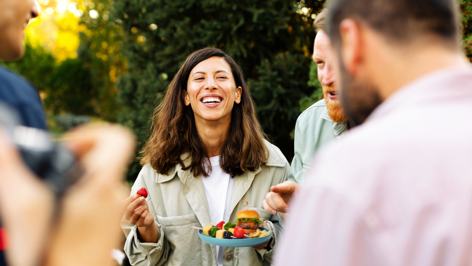 Image of woman eating strawberry at a barbeque